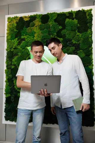 Два специалиста Webstr обсуждают проект у ноутбука в офисе